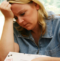 Bild: Frau stützt Kopf gegen Hand